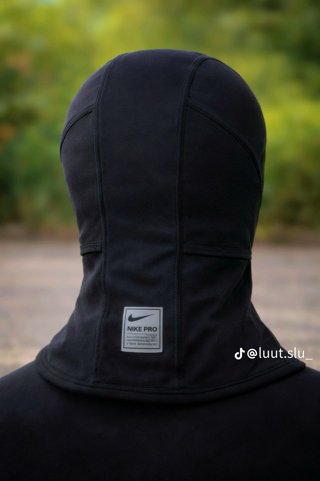 Black Nike Pro hoodie with a blurred green background