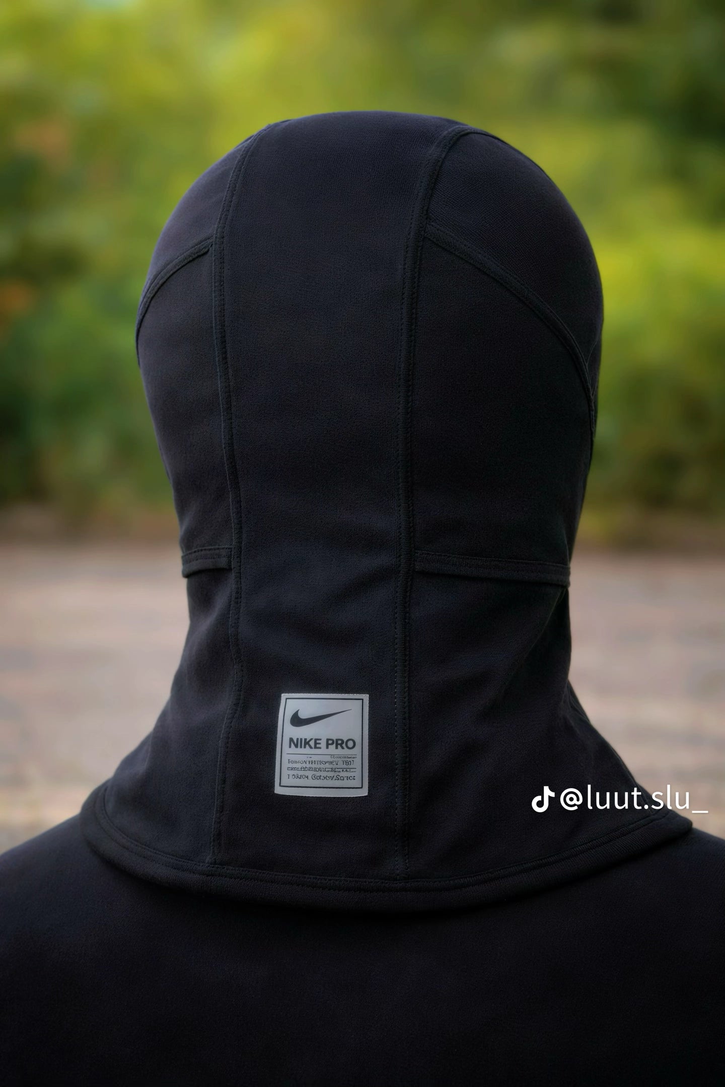 Black Nike Pro hoodie with a blurred green background